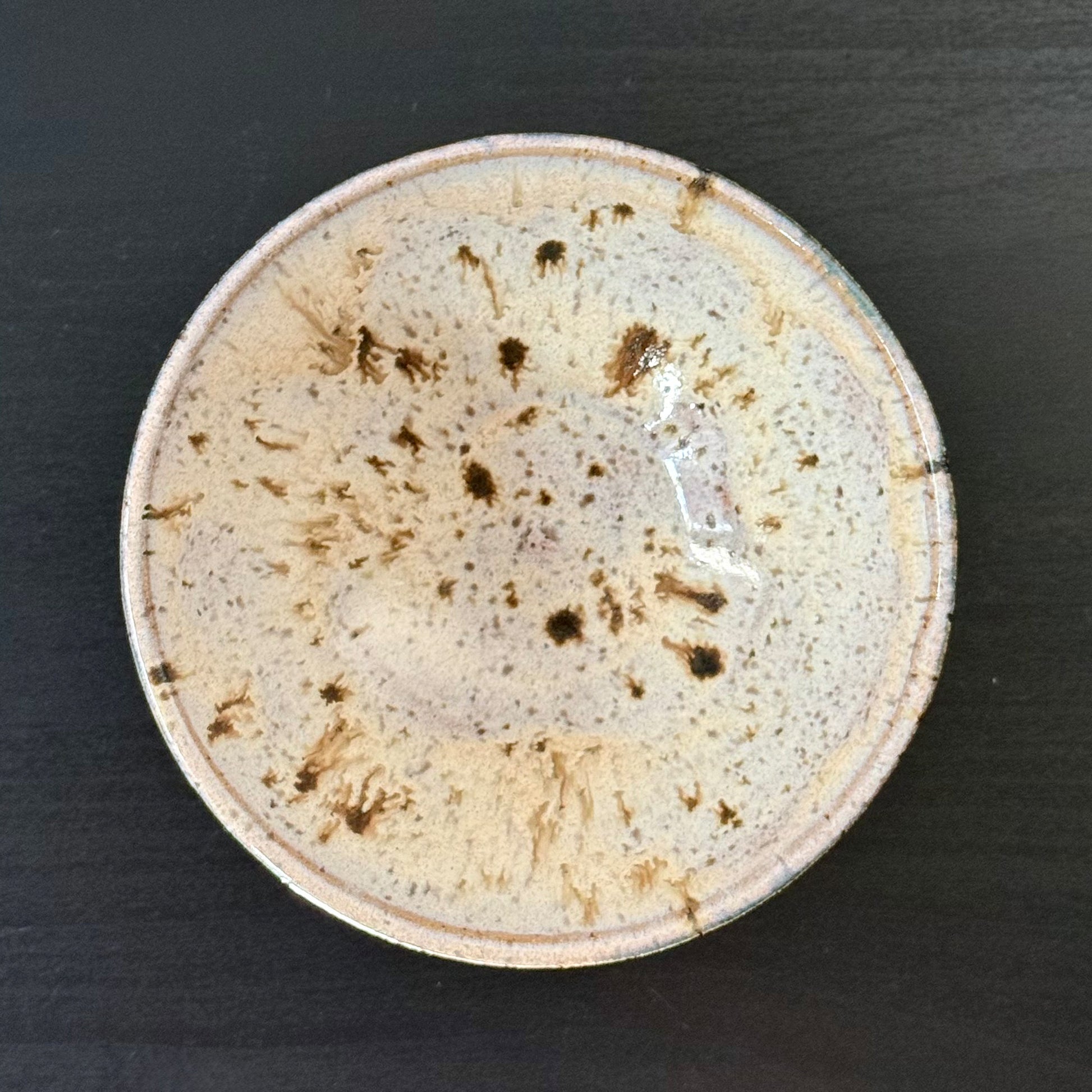 interior view of Handmade ceramic bowl with a saturated teal exterior and a creamy speckled interior, finished with a wide rounded profile and glossy glaze.