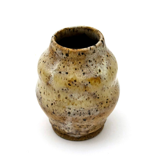 Small handmade stoneware bud vase with rounded shape and narrow opening, finished in a warm speckled glaze in cream, tan, and brown.