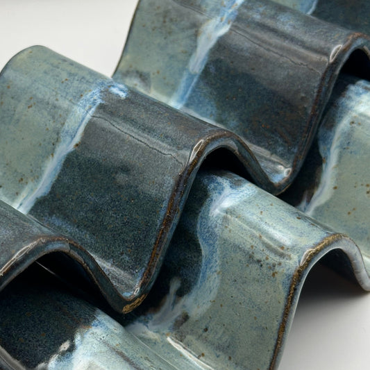 Close-up of blue ceramic taco holders on a white background