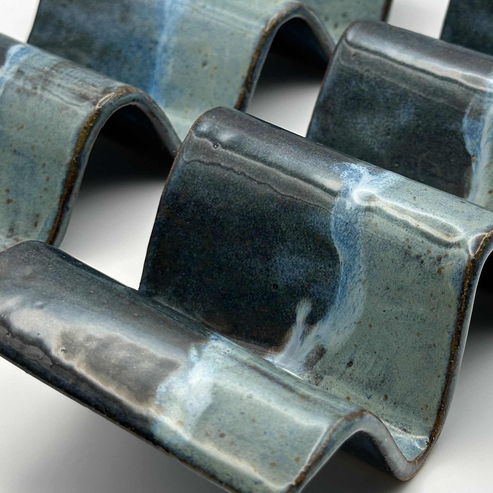 close up of blue ceramic taco holders on a light background