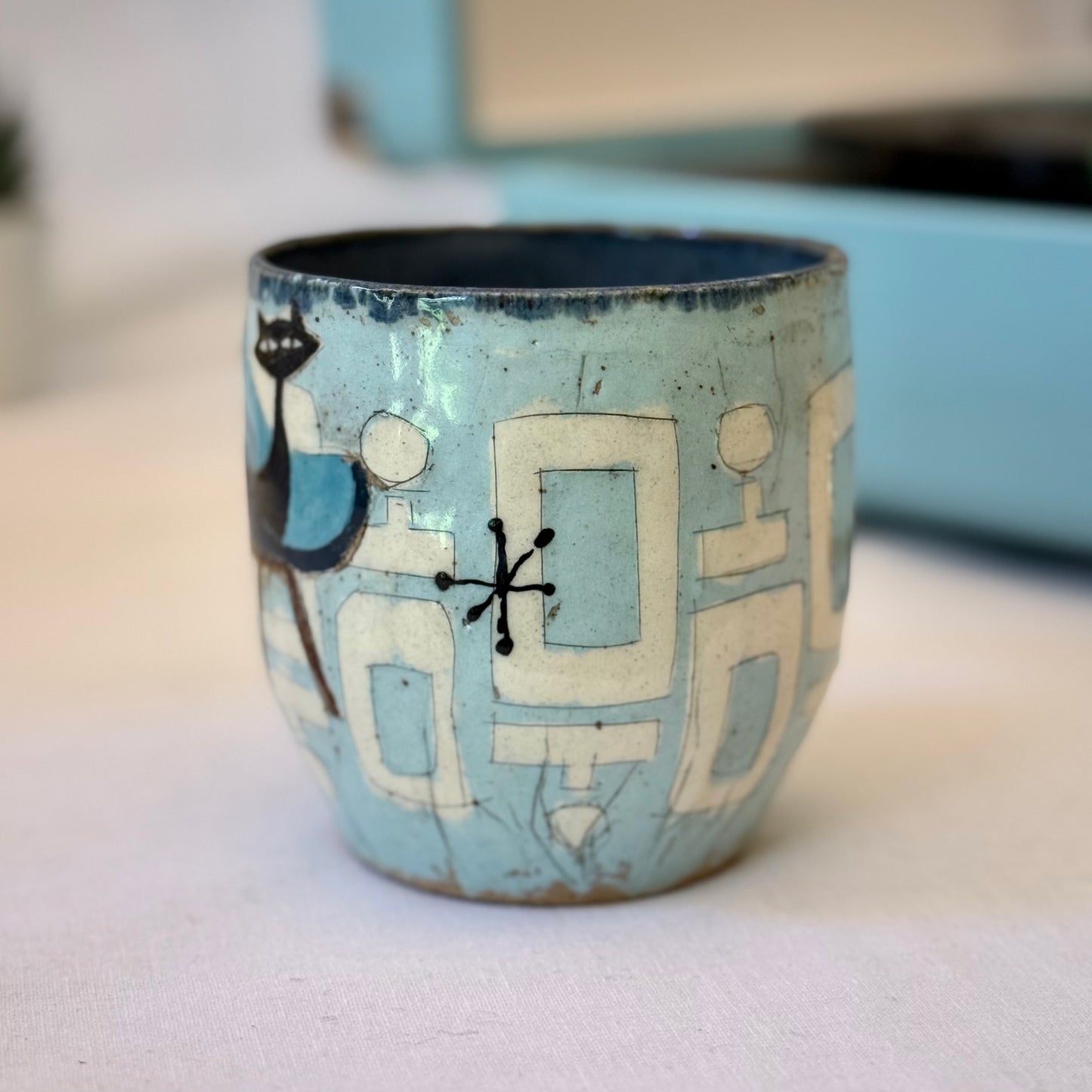 Handmade mug with black cat sitting in mid-century chair and atomic shapes