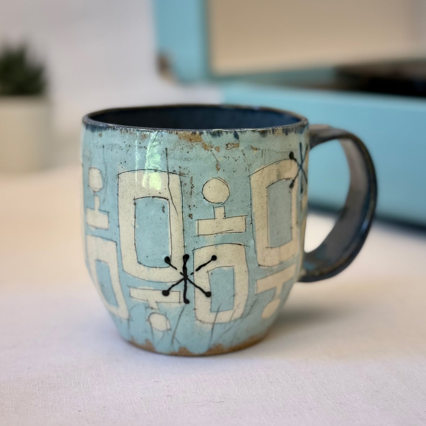 Handmade mug with black cat sitting in mid-century chair and atomic shapes