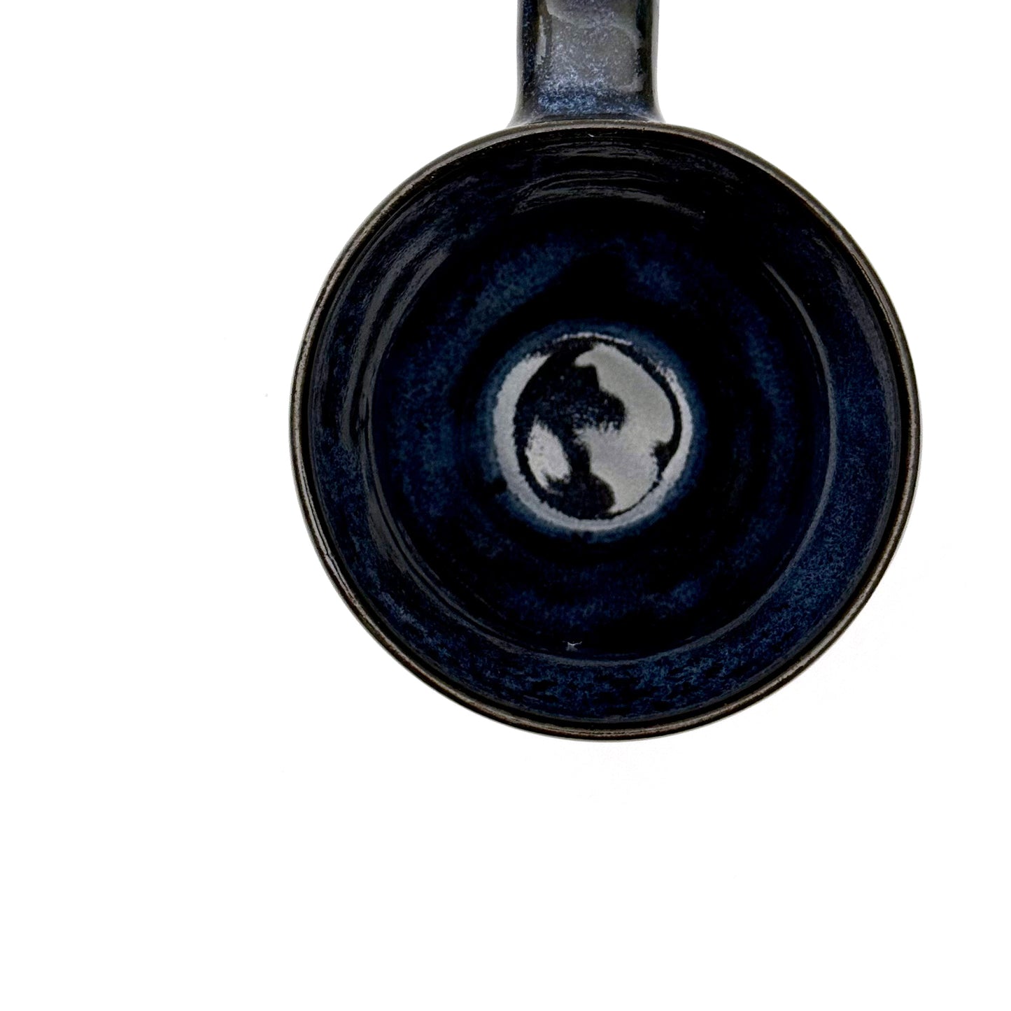 Interior view of handmade ceramic mug with a rounded shape, finished in layered blue glazes and a mid-century–inspired pattern.