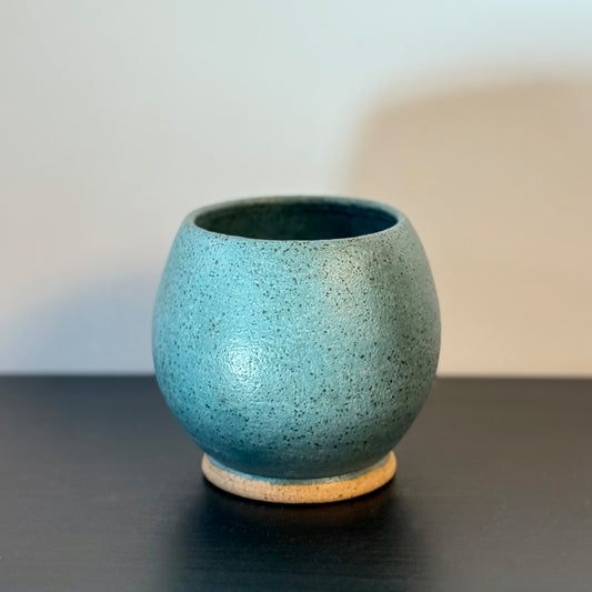 Handmade rounded ceramic vase with a saturated teal glaze, compact orb-shaped body, narrow opening, and exposed natural stoneware foot.