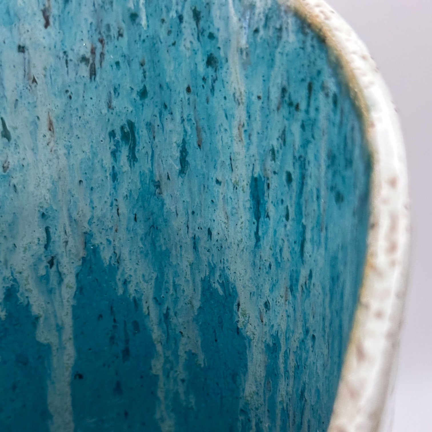 close up of white and turquoise ceramic wine chiller