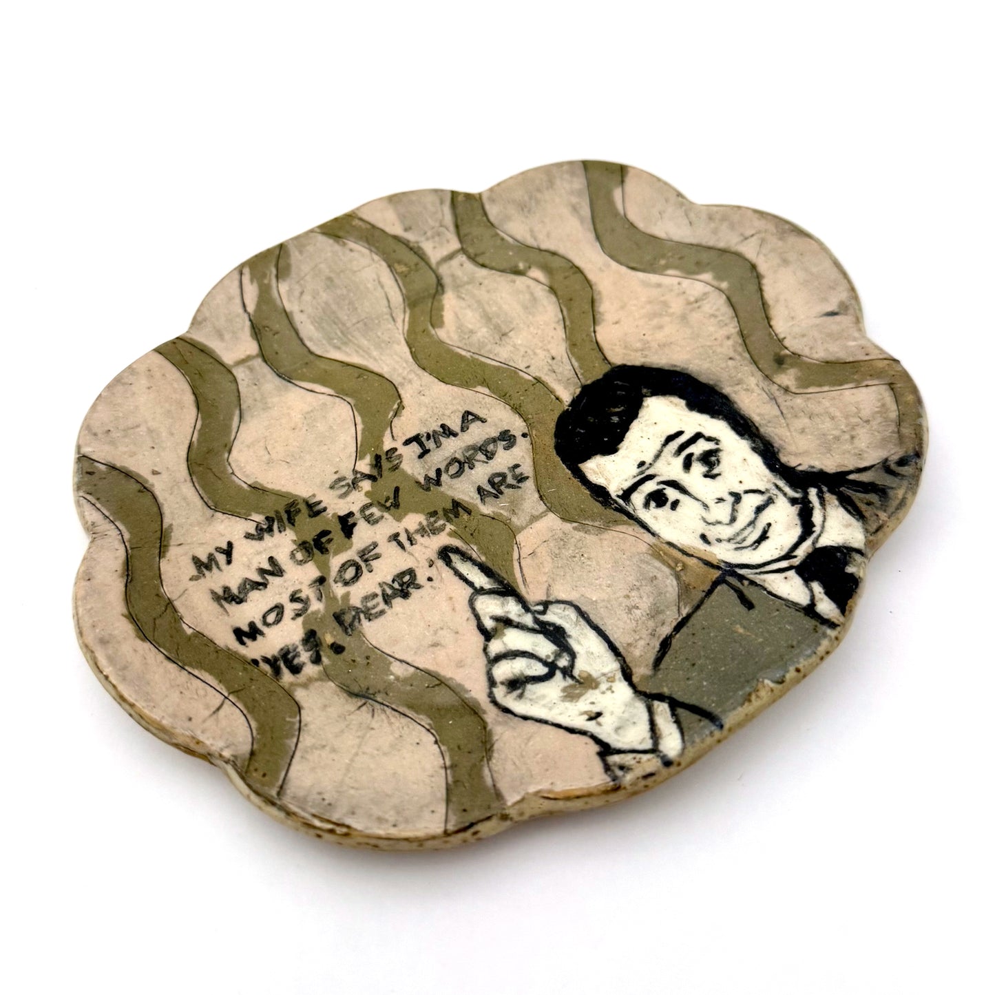 Handmade ceramic trinket dish with a scalloped edge, featuring a vintage-style illustrated man pointing upward, wavy olive-green details, and a humorous handwritten quote.