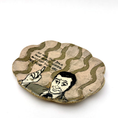 Handmade ceramic trinket dish with a scalloped edge, featuring a vintage-style illustrated man pointing upward, wavy olive-green details, and a humorous handwritten quote.