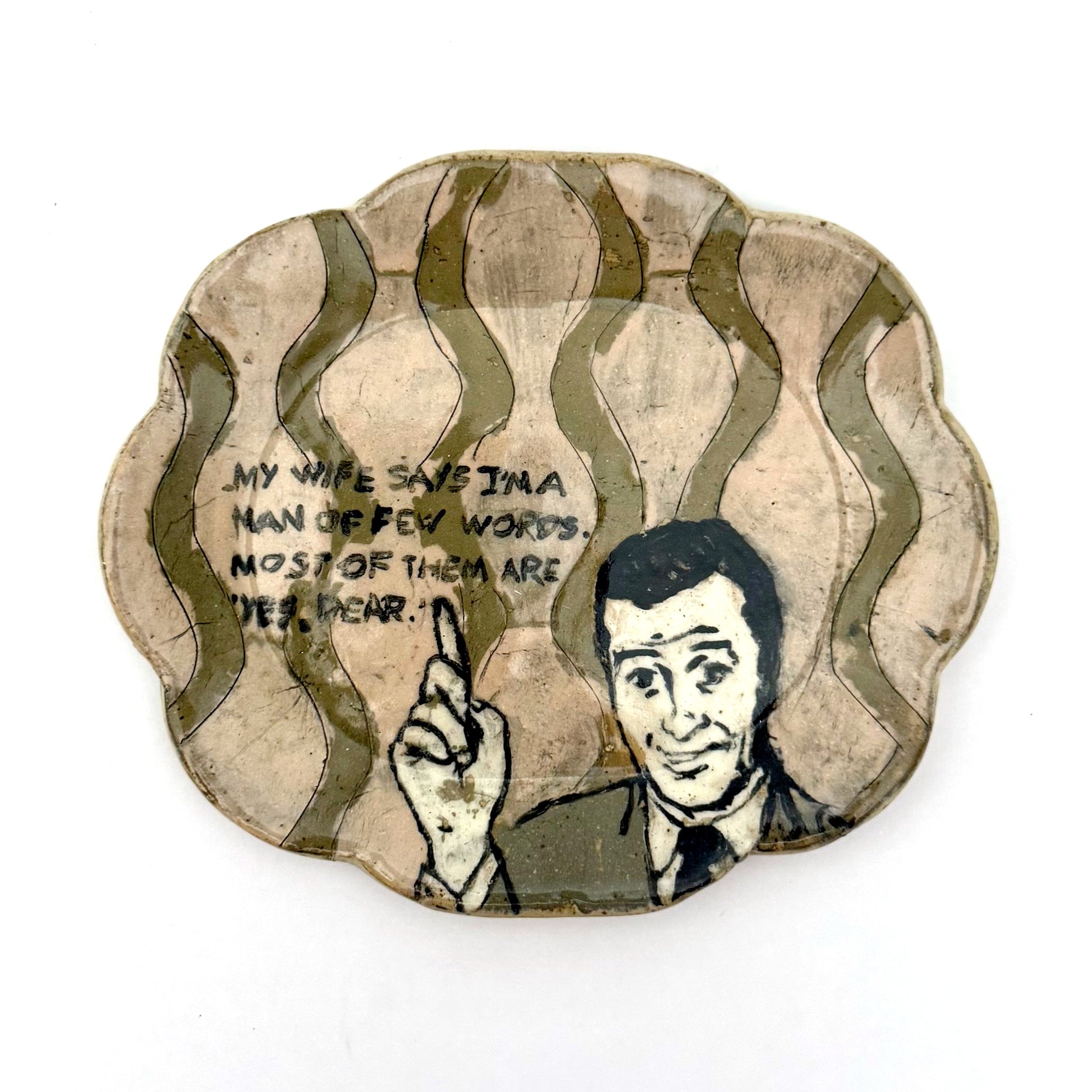 Handmade ceramic trinket dish with a scalloped edge, featuring a vintage-style illustrated man pointing upward, wavy olive-green details, and a humorous handwritten quote.