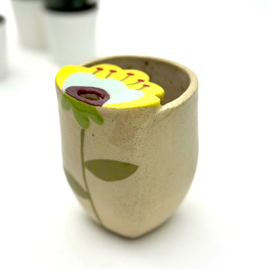 Handbuilt stoneware mug with a bold floral design on the front, finished with a smooth glaze and hand-painted details.