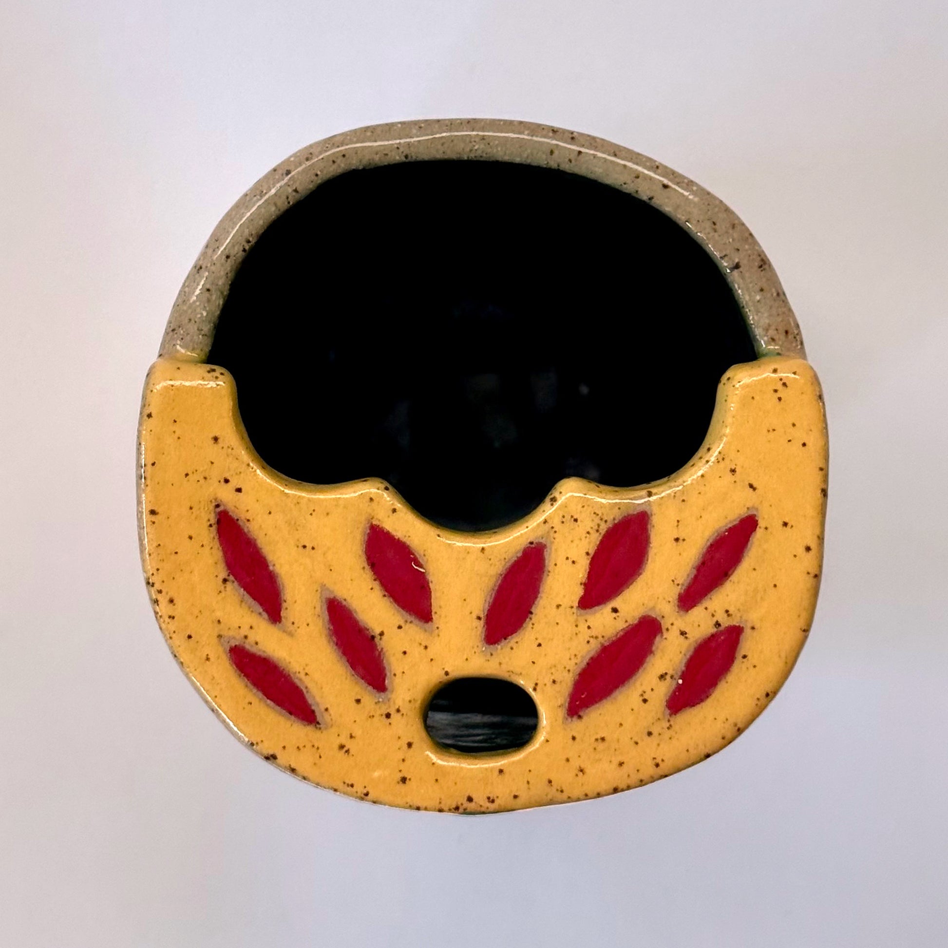 Top view of a ceramic to go mug with a black cat design on a white background